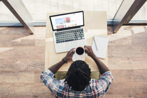 Man sitting a computer with coffee